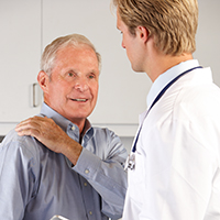 doctor with elder man holding shoulder