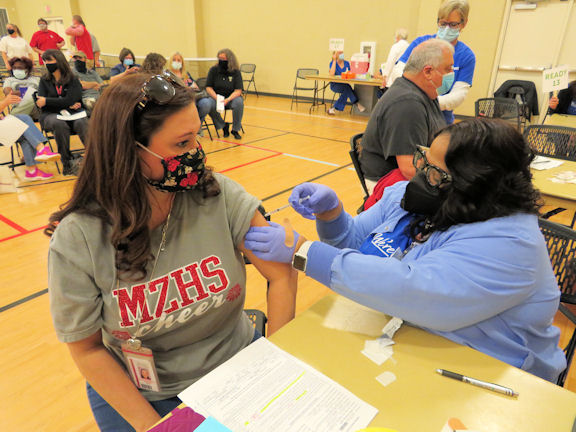 Tunicia Giron, MD, an anesthesiologist at Tanner, administers a dose of COVID-19 vaccine to Mount Zion High School physical science teacher and cheerleading coach Whitney Stringer. Tanner provided vaccines to more than 1,000 educators during the clinic event at Carrollton’s Tabernacle Baptist Church.