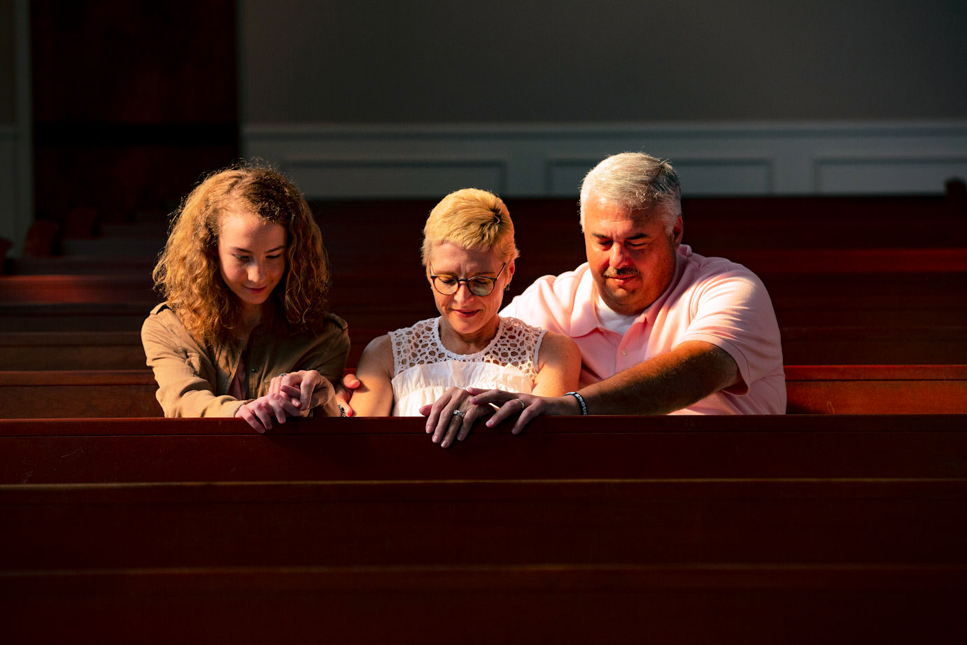 Kimberly Farmer praying with her family