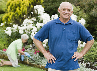 man in blue shirt standing in garden