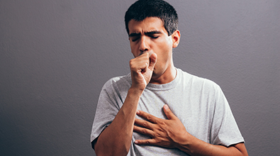 Man coughing while holding chest