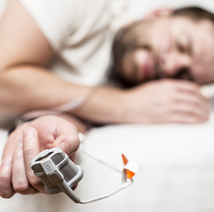 Man sleeping with oxygen monitor on hand