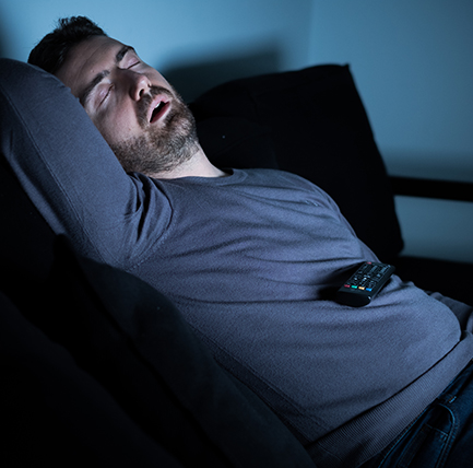 Man snoring in front of TV