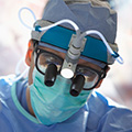 A surgeon with magnifying lenses.