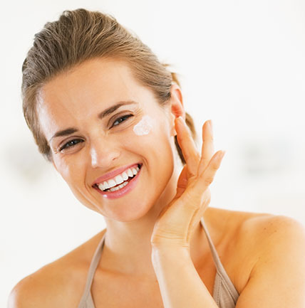 Beautiful woman applying skin cream