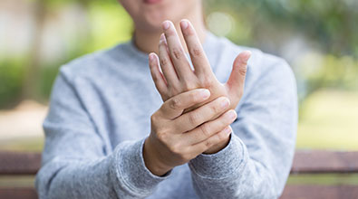 Image of a person holding their hand in pain