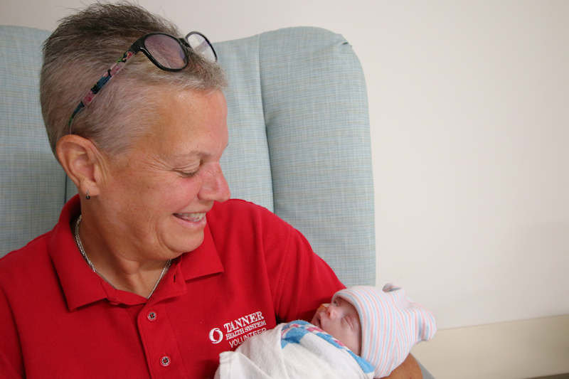 Tanner volunteer holding NICU infant