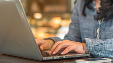 Women typing at her computer.