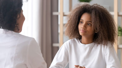 Young Black girl speaking with a therapist.
